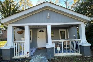 ein kleines Haus mit einer Veranda und weißen Säulen in der Unterkunft Carolina Cottage in Spartanburg