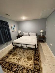 ein Schlafzimmer mit einem Bett, zwei Tischen und einem Teppich in der Unterkunft Carolina Cottage in Spartanburg