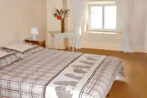 a bedroom with a bed and a window and a table at Maison charmante à Ranrupt avec jardin et terrasse in Grandrupt