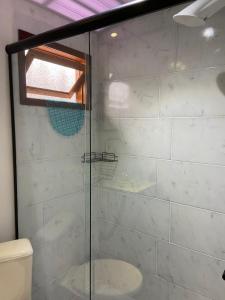 een badkamer met een glazen douche met toilet bij Chalé Black no Sul da Ilha in Florianópolis +9 foto's