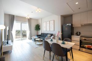 アブダビにあるF1 Dreamstay 1bhk Gym Poolのキッチンとテーブルとソファのあるリビングルーム