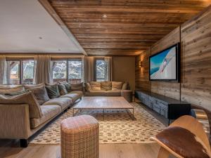 a living room with a couch and a tv at Duplex de Prestige 6 Chambres, Route du Belvédère, Skis aux Pieds, Jacuzzi & Parking Privé - FR-1-613-8 in Méribel
