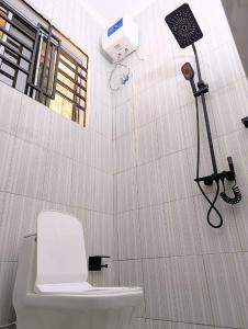 a bathroom with a toilet and a camera on the wall at Jegestal Serenity Homestay Camping and Tours in Lushoto