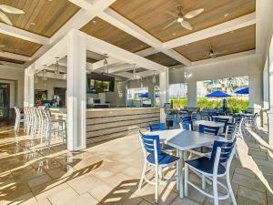 a patio with a table and chairs and a bar at Disney Magic ChampionsGate Resort Town Home 15 min from Disney World, 7 Pools, Gym, Golf, Arcade, Water Park and more! in Kissimmee