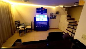 a living room with a television and a table and stairs at Multiplex Unique DOCA cop30 in Belém +7 photos