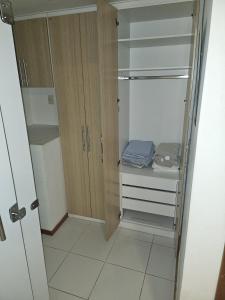 a walk in closet with wooden cabinets and blue towels at Multiplex Unique DOCA cop30 in Belém