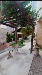 a wooden pergola with a bench on a patio at Multiplex Unique DOCA cop30 in Belém