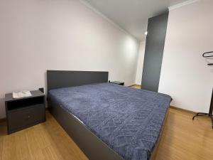 Schlafzimmer mit einem Bett und einem Beistelltisch in der Unterkunft Villa chimbulak in Almaty