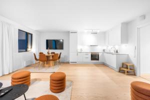 a white kitchen with a table and a dining room at Northern Lights Haven 2BD Apartment sea view in Tromsø