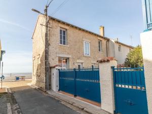 a house with a blue gate and a fence at Studio climatisé avec terrasse vue mer, garage et wifi - FR-1-535-63 in Châtelaillon-Plage