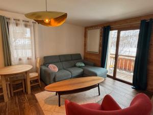 un salon avec un canapé et une table dans l'établissement Charmant appart à 50m des pistes, balcon, parking - FR-1-445-215, à Montgenèvre