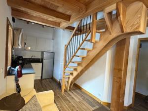 un salon avec un escalier en bois dans une petite maison dans l'établissement Superbe duplex 5 pers à Montgenèvre avec parking privé - FR-1-445-216, à Montgenèvre 8 autres photos