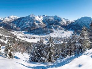 une chaîne de montagnes enneigée avec des arbres et une ville dans l'établissement Superbe duplex montagnard luxe pour 6 pers. à Montgenèvre - FR-1-445-214, à Montgenèvre 7 autres photos