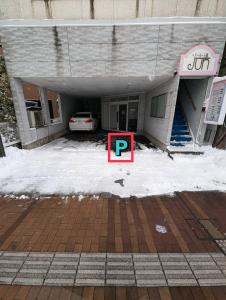 a parking lot with a parking sign in front of a building at 8人で泊れる ペットと泊まれる宿 DoggoInnn Akita in Akita