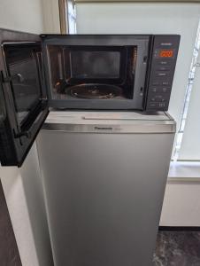 a microwave oven sitting on top of a refrigerator at 8人で泊れる ペットと泊まれる宿 DoggoInnn Akita in Akita