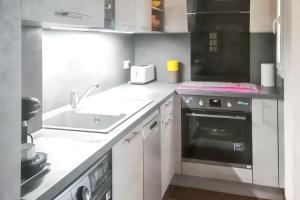a small kitchen with a sink and a stove at Appartement confortable avec vue sur la mer à Port Leucate, 50 m² in Leucate +5 photos
