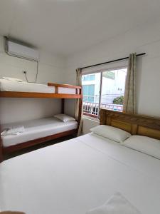 ネコクリにあるCasa Hotel Mar y Brisa Beachの二段ベッド2台と窓のある寝室