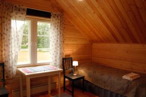 ein Schlafzimmer mit Bett, Schreibtisch und Fenster in der Unterkunft Lomakivi in Kausala