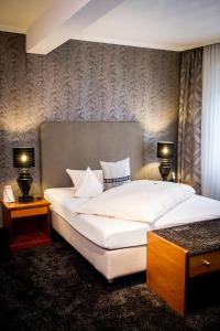 a bedroom with a large white bed with two lamps at Haus Anna an der Stadtmauer in Hanau am Main