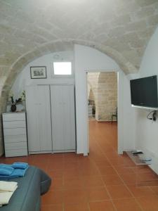 a living room with a couch and a flat screen tv at Casa vacanza nel cuore della pietra in Barletta