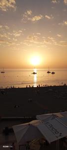 un grupo de personas en una playa al atardecer en Aquamarina Dream, en Costa del Silencio