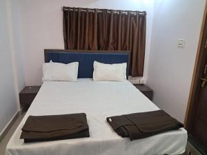 a bedroom with a large bed with a blue headboard at Aahvaanam in Kurnool +1 photo