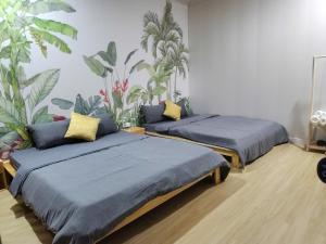 two beds in a room with plants on the wall at Mui Ne Stay & Invest Guest House in Ấp Thiện Phước