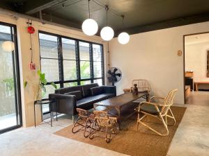 a living room with a couch and a table and chairs at GalileOasis Boutique Hotel in Bangkok