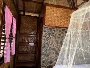 a bedroom with a bed with a net curtain at MALAIKA RESORT in San Vicente +3 photos