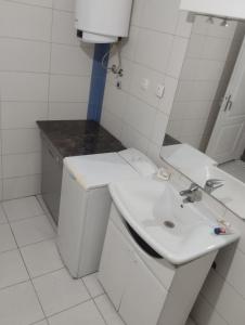 een witte badkamer met een wastafel en een spiegel bij Summer house Belgrade in Belgrado