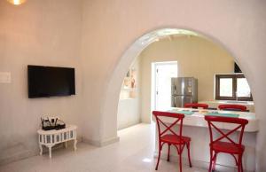 a living room with a table and two red chairs at Casa Recanto - Cosy one bhk house in Sangolda, Goa in Sangolda