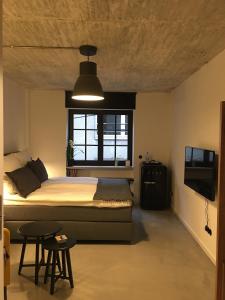 a bedroom with a bed and a window and a television at Square Rooms 8 in Düsseldorf