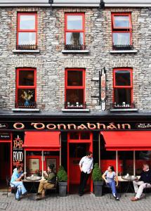 un grupo de personas sentadas en mesas fuera de un restaurante en O'Donnabhain's en Kenmare