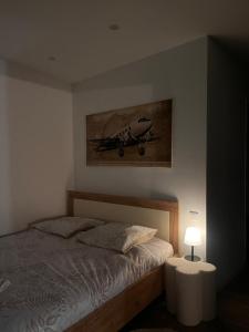 a bedroom with a bed and a painting on the wall at Écrin des nuages in Cognac