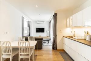 une cuisine et un salon avec une table et des chaises dans l'établissement Large condo Surin-Bangtao Beach, à Ban Lum Fuang