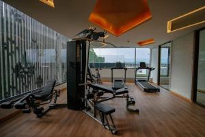 une salle de sport avec plusieurs tapis de course et une grande fenêtre dans l'établissement Large condo Surin-Bangtao Beach, à Ban Lum Fuang