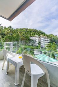 un balcon avec une table et des chaises et une vue dans l'établissement Large condo Surin-Bangtao Beach, à Ban Lum Fuang