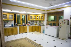 a kitchen with yellow cabinets and a white refrigerator at Kashmir Cottage Muzaffarabad in Muzaffarabad