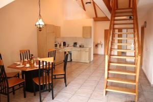 a kitchen and dining room with a table and a staircase at Ferienhaus Gleissbuck in Schönbronn