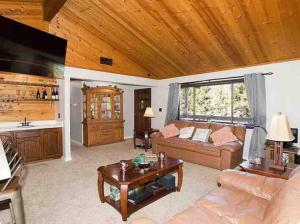 una sala de estar con un sofá y una mesa en Sandalwood, en Pine Mountain Club