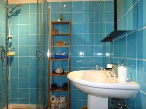 y baño de azulejos azules con lavabo y ducha. en Studio 23, en Trieste 41 fotos más
