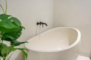 a white toilet in a bathroom with a plant at Alisa 4 - Brand New Villa with Breathtaking Garden Views - Expansive Pool - 4 Luxury Bedrooms in Seminyak