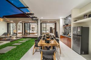 a kitchen and living room with a table and chairs at Alisa 4 - Brand New Villa with Breathtaking Garden Views - Expansive Pool - 4 Luxury Bedrooms in Seminyak