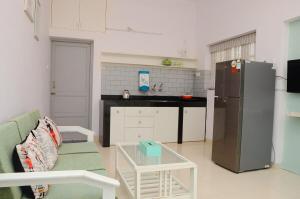 a kitchen with a couch and a refrigerator and a table at Casa Sea-Esta, Beach view studio apt - Dona Paula in Panaji