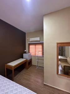 a bedroom with a bed and a desk and a window at Santai Salai Homestay and Cafe in Kepala Batas