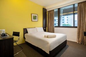 a hotel room with a large bed and a window at The Quay Hotel Little India at Broadway in Singapore