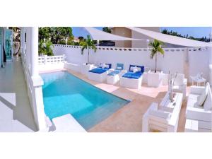 una piscina con muebles blancos y una piscina en Champartments Resort - Villa & Appartementen Dom Perignon, en Willemstad