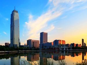 a city skyline with skyscrapers and a body of water at AOLUGUYA in Harbin
