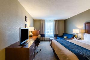 a hotel room with a bed and a flat screen tv at Comfort Inn Randolph-Boston in Randolph +40 photos