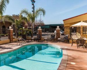 a swimming pool at a resort with chairs and a table at Quality Inn Near Chico State in Chico